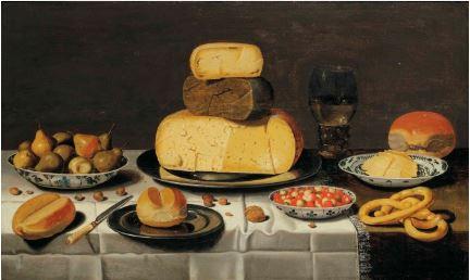 A breakfast with cheese, bread, fruit and roemer, on a partially draped table